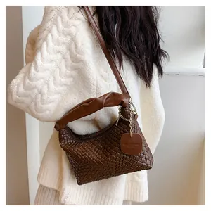 Détail de la texture tissée à la main et de la poignée nouée sur le sac à bandoulière brun