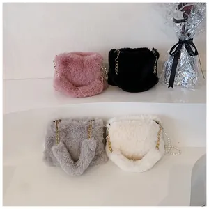 Detailed view of plush faux fur handbags in pink black and white with pearl chain straps