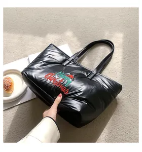 Détail du sac cabas matelassé noir avec broderie de Noël et accent de chapeau festif