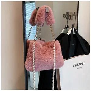 Detail of pink plush crossbody bag featuring elegant faux pearl chains and soft fur texture