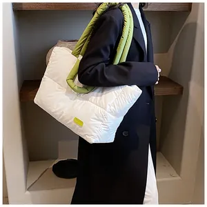 Détail du sac cabas matelassé avec des poignées vert vif et une étiquette mode