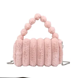 Pink plush faux fur handbag with stylish pom-pom handle and silver chain strap