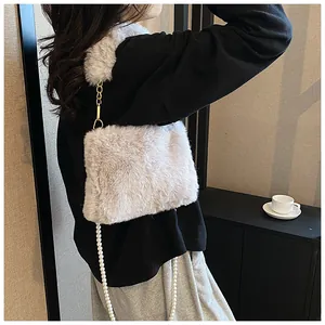 Detail of light grey faux fur crossbody bag with elegant white pearl chain strap