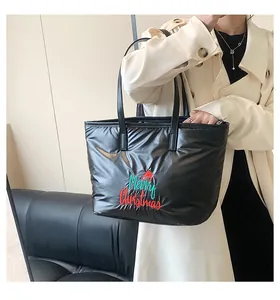 Détail d'un sac cabas noir matelassé avec une broderie festive de Merry Christmas