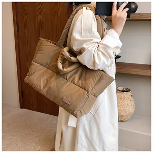 Détail du sac fourre-tout matelassé en nylon kaki avec bandoulière et étiquette mode