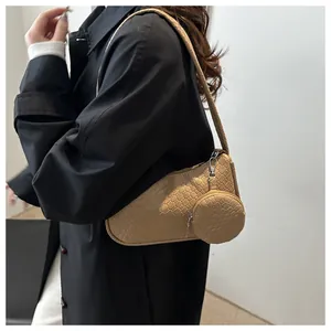 Detail of khaki shoulder bag with woven texture, featuring a mini round coin purse detail