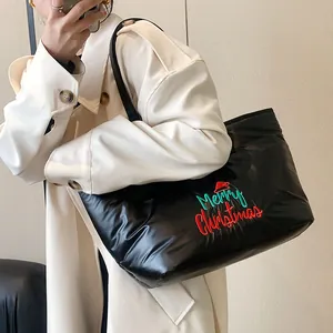Sac fourre-tout matelassé noir avec broderie Merry Christmas porté par un mannequin