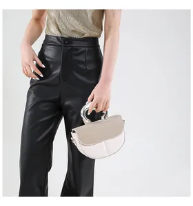 Minimalistische beige Satteltasche mit gewebter Klappe und großem silbernem Ringgriff