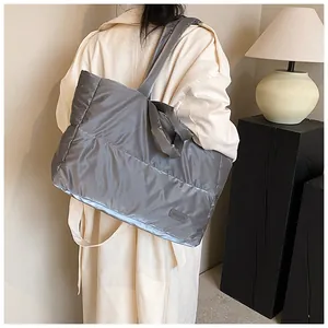 Détail d'un sac cabas matelassé gris clair avec étiquette mode vue de l'arrière