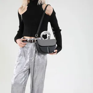 Minimalistische graue und schwarze Umhängetasche mit silbernem Griff am Modell