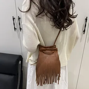 Braune Vintage-Tasche aus Kunstleder mit Fransen und Kordelzug am Modell getragen