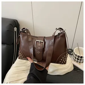 Dettaglio della borsa in similpelle marrone con borchie e fibbia in argento lucido