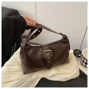 Dettaglio borsa tote marrone scuro con borchie argentate e fibbia metallica