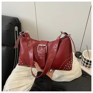 Dettaglio borsa tote rossa con borchie, fibbia in metallo Y2K e tracolla con occhielli