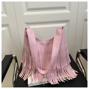 Makro-Detail der rosa PU-Schultertasche mit mehrlagigen langen Fransen und Quasten