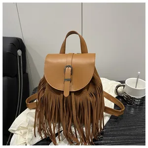 Detail of caramel faux leather backpack with long fringe and vintage buckle closure