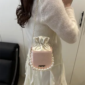 Pink snakeskin pattern bucket bag with pearl handle and golden chain strap