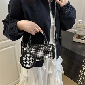 Black cylinder crossbody bag with silver rivets and mini round coin purse detail