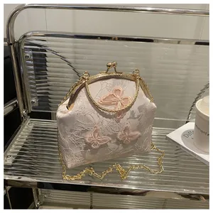Detailed close-up of lace embroidery and pink butterfly appliques on vintage handbag