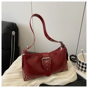 Dettaglio borsa a spalla vintage rosso scuro con borchie argentate e fibbia metallo
