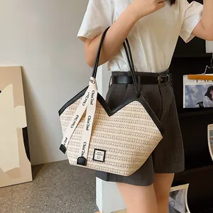 Handwoven straw tote bag with black leather trim and large capacity shown on a model