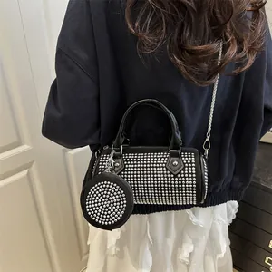 Chic black cylinder crossbody bag with silver rivet studs and matching coin purse charm