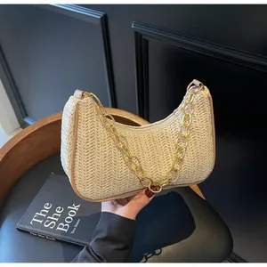 Detail der handgewebten Stroh-Schultertasche mit goldener Kette und Reißverschluss