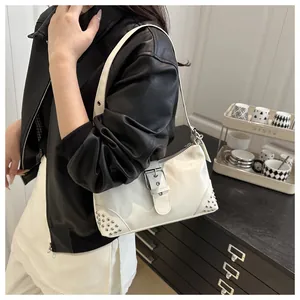 Borsa tote bianca lucida con borchie argentate e tracolla indossata da una modella