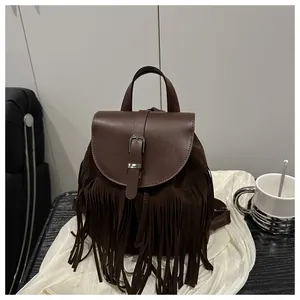 Detailed macro shot of vintage dark brown leather backpack with long fringe and metal buckle