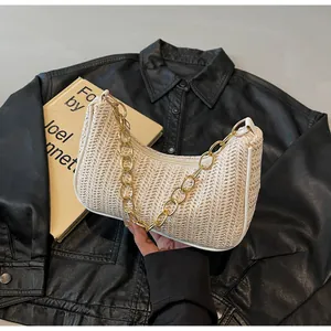 Detail der beige gewebten Hobo-Bag mit V-Muster und klobiger goldener Kette
