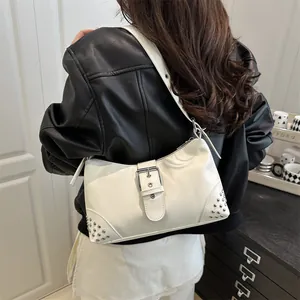 Borsa tote bianca con borchie e fibbia mostrata sulla spalla di una modella