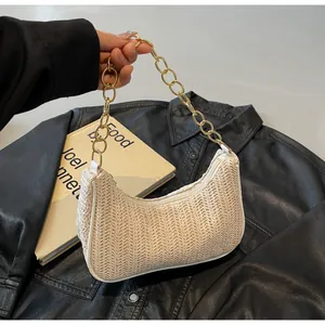 Detail der beigen geflochtenen Hobo-Tasche mit Fischgrätmuster und goldener Kette