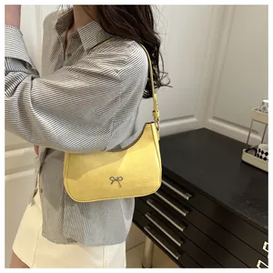 Detail der gelben Hobo-Tasche mit Kroko-Prägung und silbernem Schleifen-Anhänger