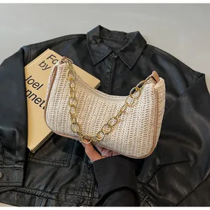 Detail der cremefarbenen geflochtenen Tasche mit Goldkette und Lederbesatz