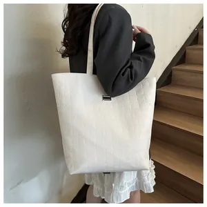 Detail view of large white crocodile embossed tote bag with metal buckle decoration