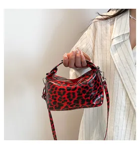 Primer plano del bolso tote de leopardo rojo y negro con acabado de charol brillante
