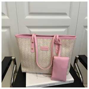 Dettaglio della trama intrecciata e finiture in pelle rosa con logo su borsa tote