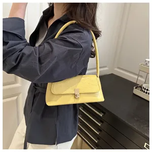 Sac baguette jaune à motif crocodile avec boucle dorée et fine bandoulière élégante