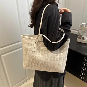 Grande borsa tote in paglia beige con finiture in pelle bianca su una modella