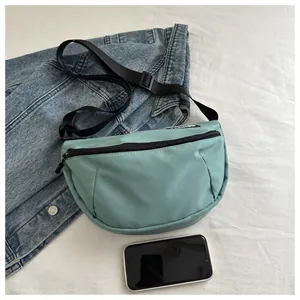 Detail of mint green nylon crescent bag with adjustable strap and fashion label tag