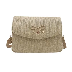 Borsa a tracolla intrecciata estiva con fiocco in metallo dorato e cinturino in pelle