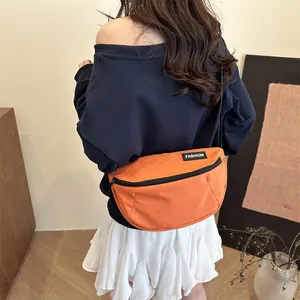 Outdoor vibrant orange nylon crossbody bag with fashion label on navy blue hoodie