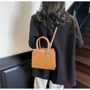 Brown monogram mini tote bag with dual handles and long strap shown on a model