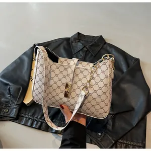 Dettaglio della borsa baguette bianca con motivo geometrico e chiusura in metallo dorato