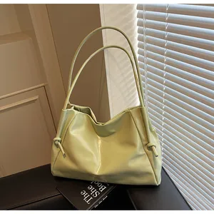 Detail of light green faux leather tote with decorative side knots and soft pleats