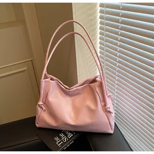 Detail shot of a pink pleated tote bag with double straps and metallic gold buckle