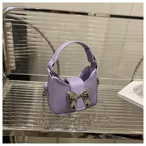 Détail macro du sac à main en cuir PU lilas avec un grand nœud en métal argenté