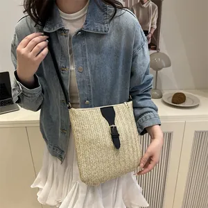 Minimalist straw woven crossbody bag with black leather strap for summer beach vacation