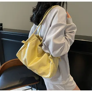 Detail of soft yellow faux leather tote bag with unique knot decoration on shoulder strap