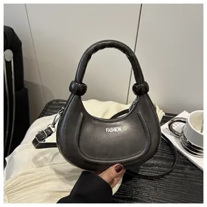 Detail of matte dark grey crescent bag with FASHION text and silver-tone hardware